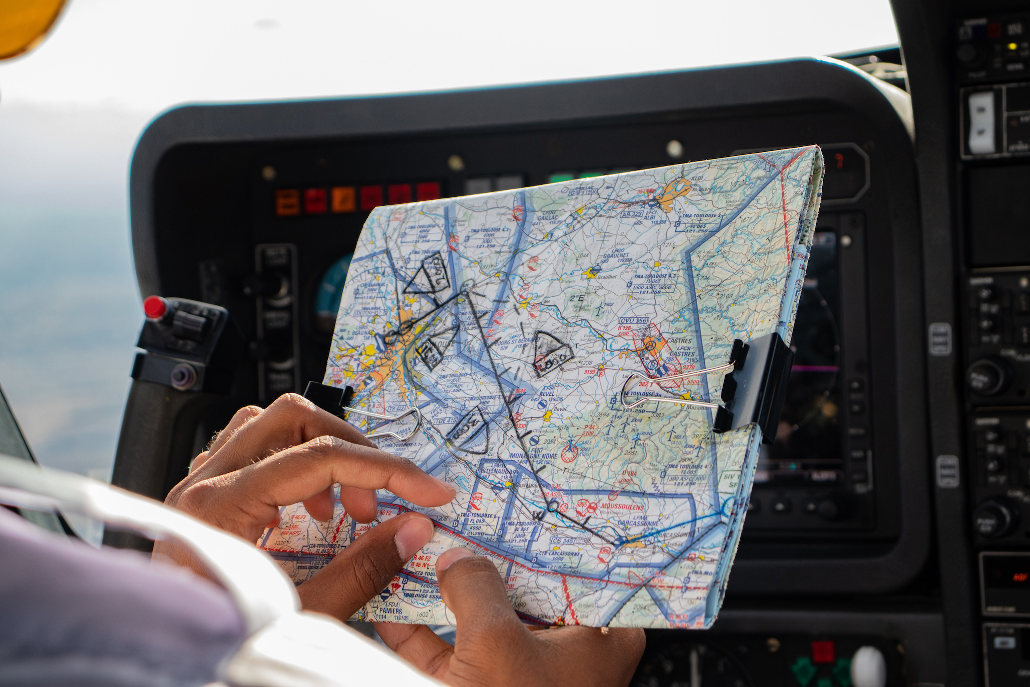 An EPL student in the cockpit reviewing his VFR map during a navigation flight